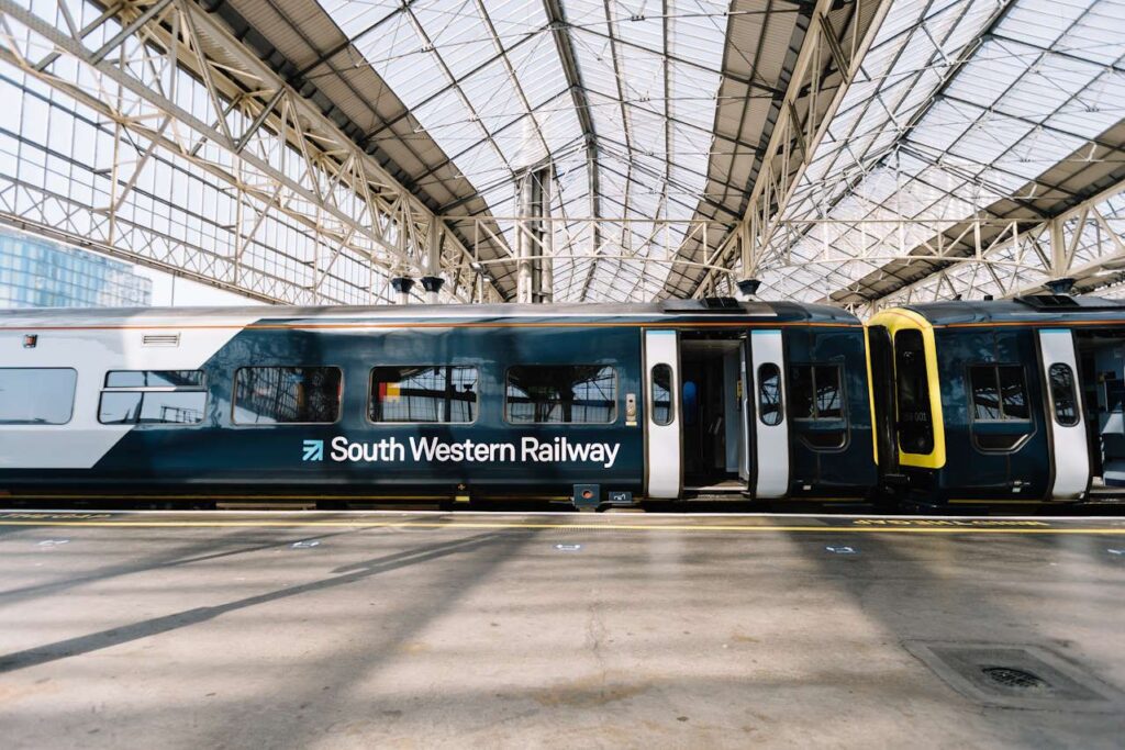 Southwestern Railway train idling at a Waterloo station with its doors open onto a platform